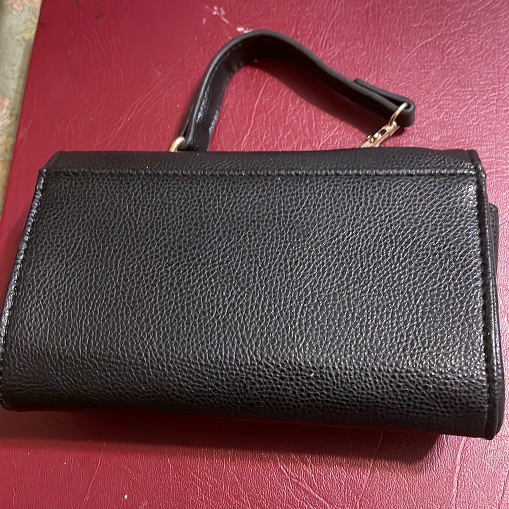 Black small purse with gold chain for evening wear or shopping.